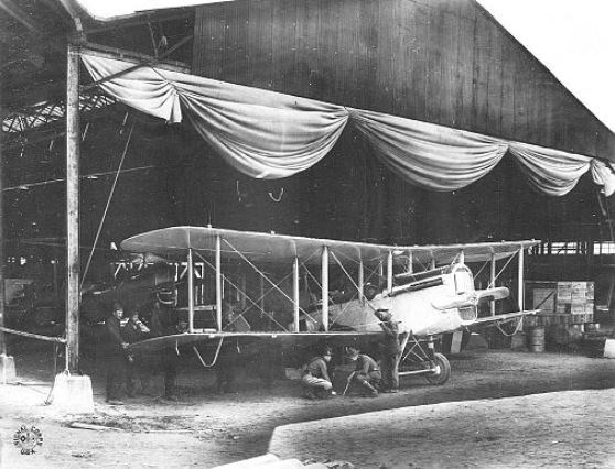 Biplane being assembled in a hangar