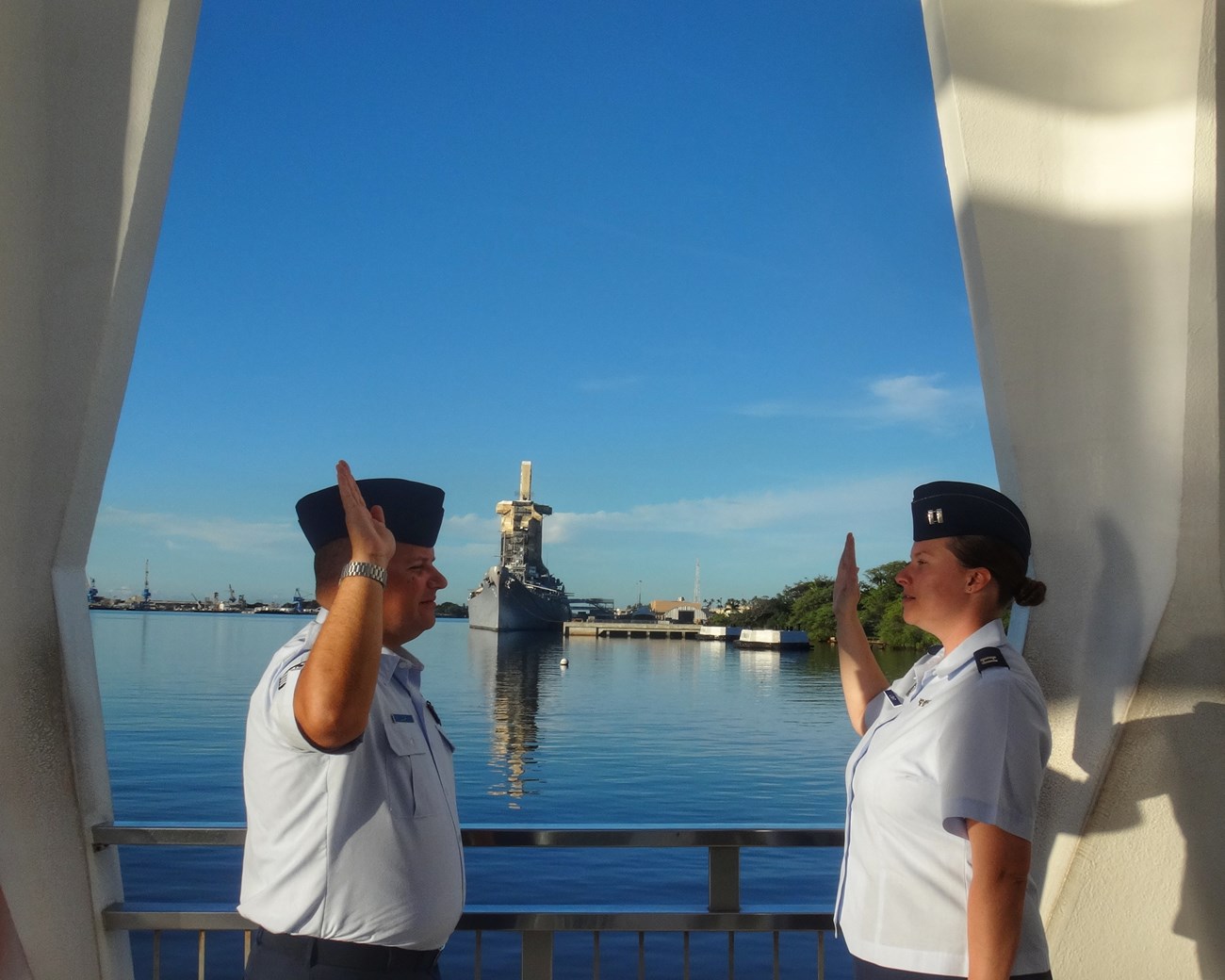 Captain Light administers the Oath of Enlistment to SSgt Loar People in Air Force uniforms facing each other with right arms raised.