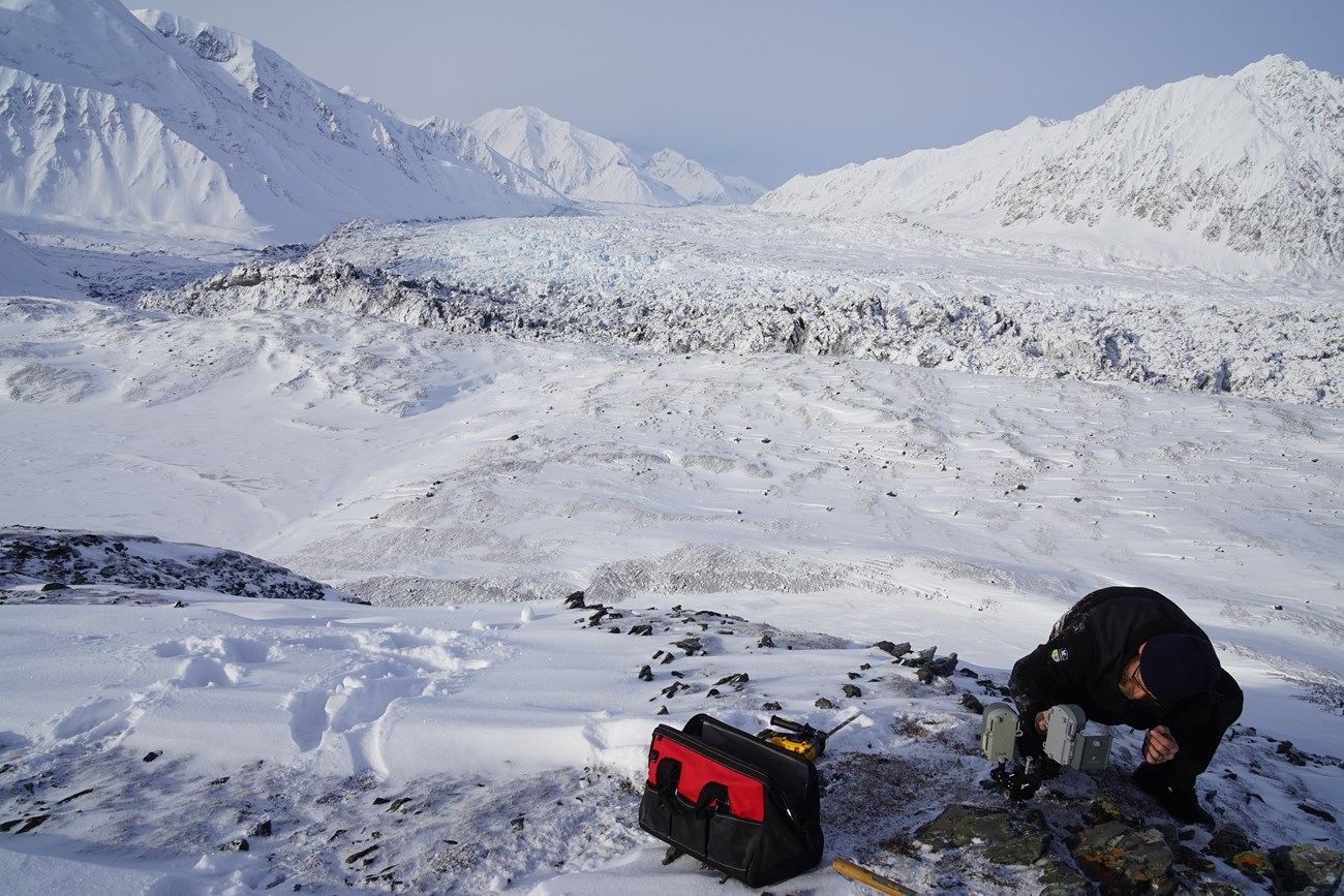 a man setting up a camera in snow
