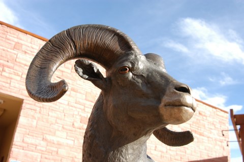 a bronze sculpture of a bighorn sheep with curled horns