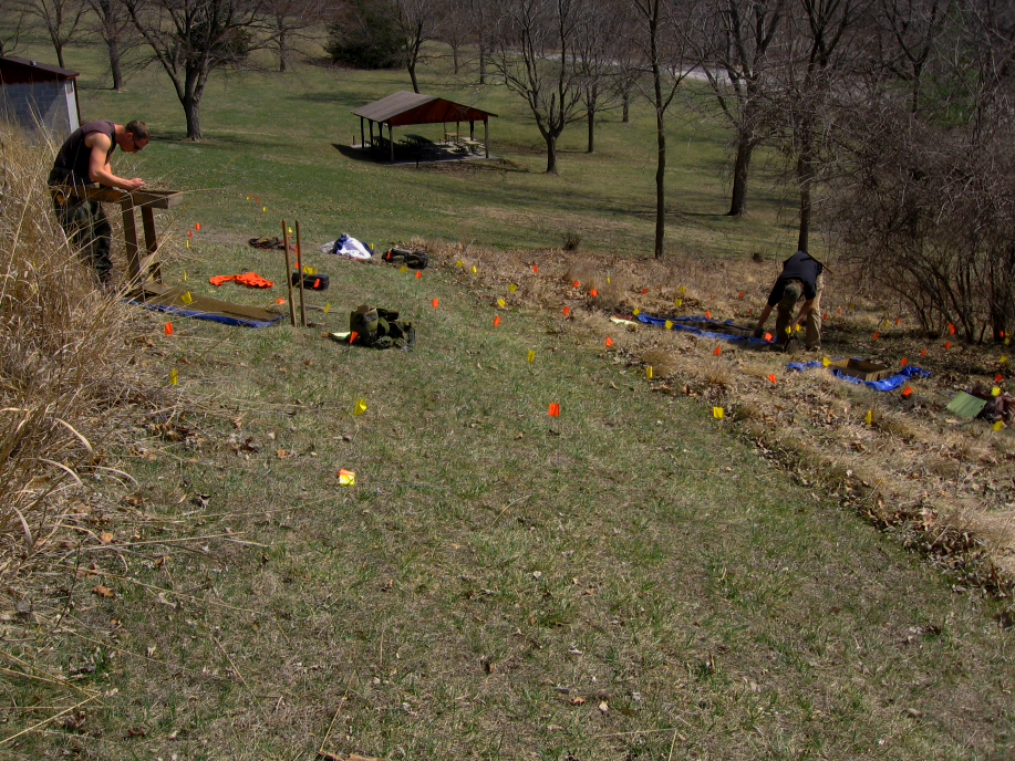 People marking a field with colorful flags.