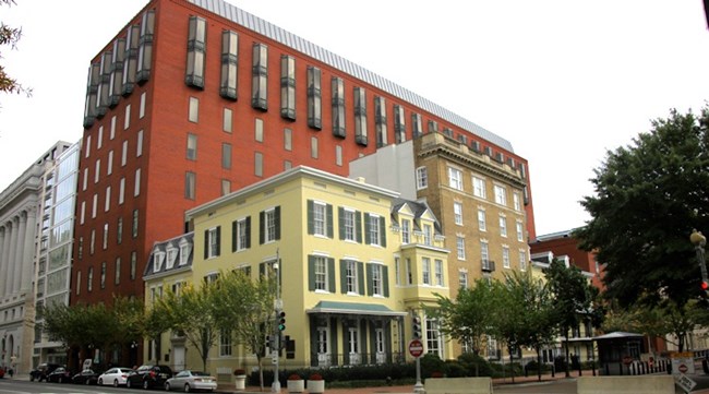 Modern brick office building behind historic homes