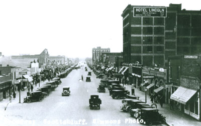 B&W photo of buildings and a street with cars.