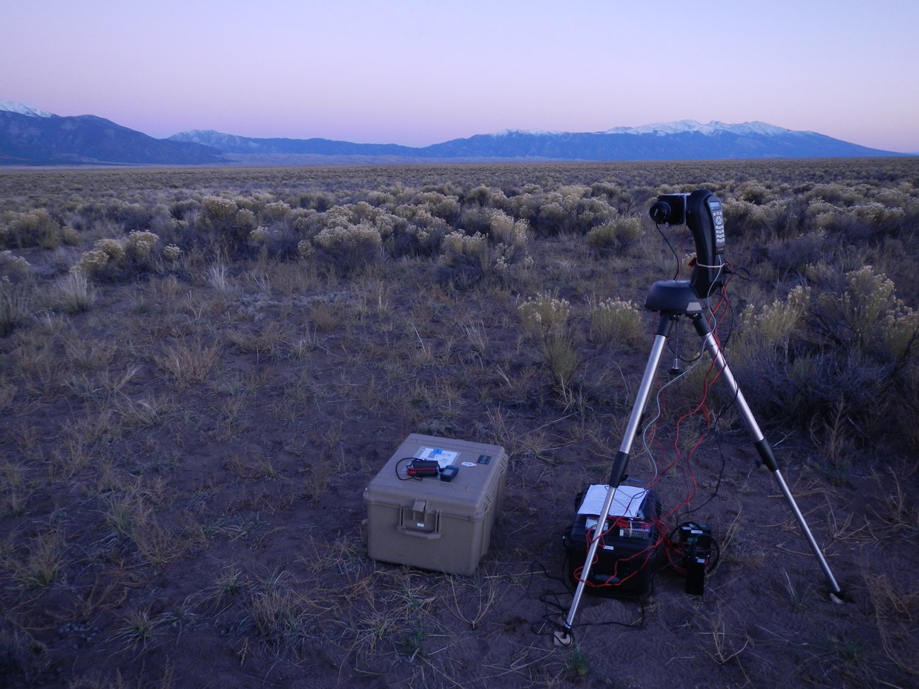 The night sky CCD camera is installed in a high desert prairie location with snow-capped mountains beyond.