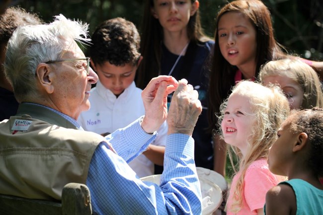 Naturalist E.O. Wilson shows an object to children.