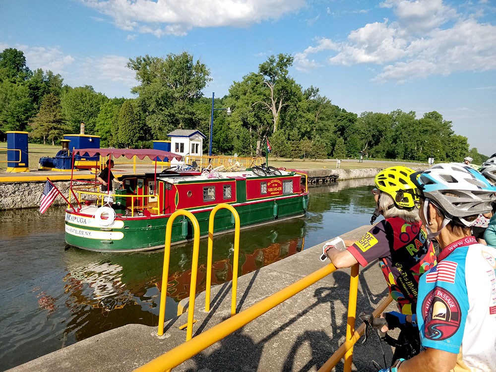 Cyclists stop to look at a boat in the canal.