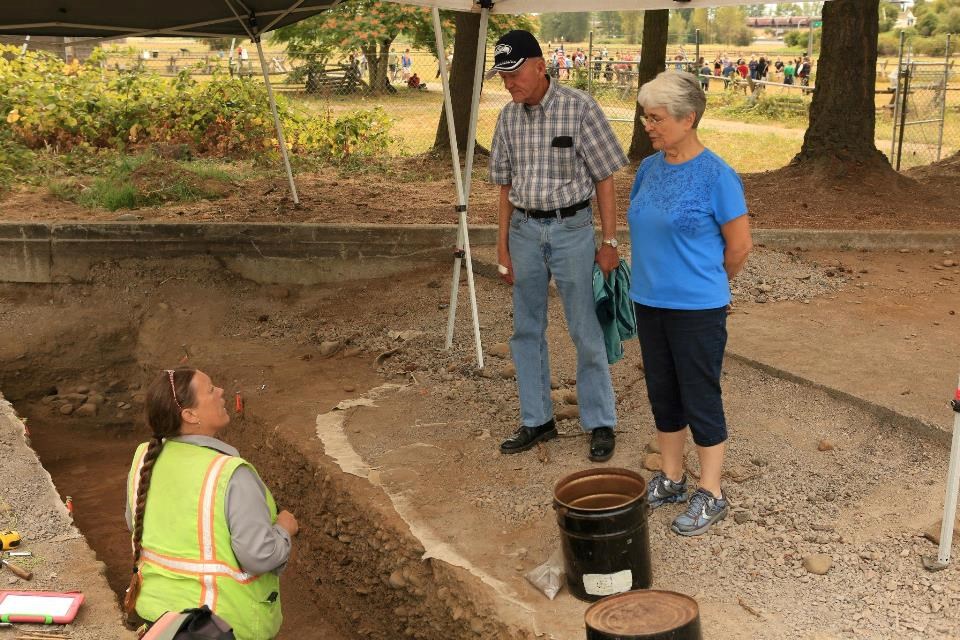 Photograph of archaeologist standing in excavation unit