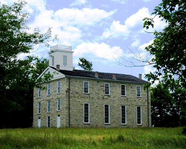 Stone building with a black and white roof.