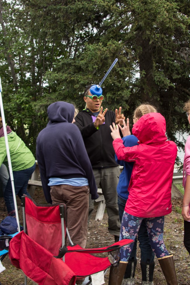 youth and adults outside near camp chairs