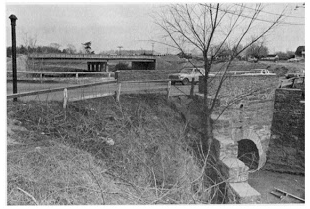 black and white photo of road crossing above culvert