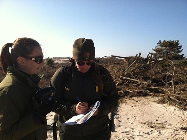 Resource advisors assess a damaged boardwalk at Fire Island National Seashore after Hurricane Sandy. Before GeoJot, READs had to use a pen and paper for data collection.