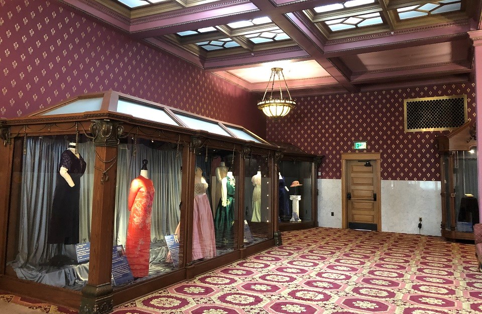 FILA Education Center 3 Museum exhibit with a line of historical dresses in glass cases