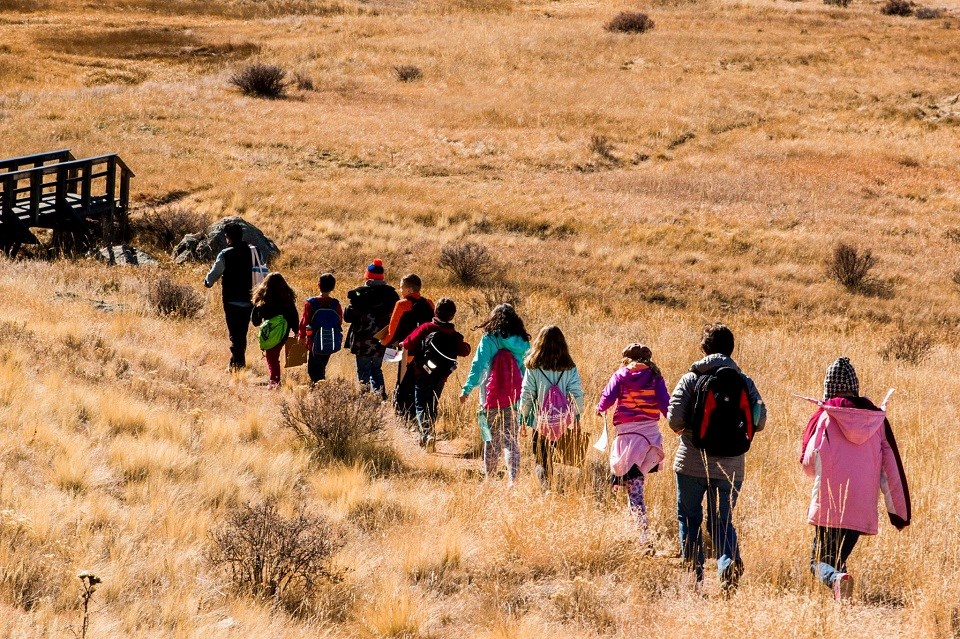 FLFO Kids Hiking Line of kids hiking through a field
