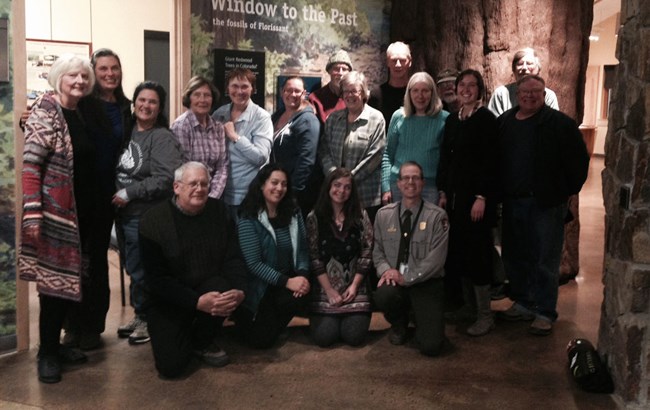 Volunteers at Florrisant Fossil Beds National Monument. People standing together and smiling to pose for a photo inside a building.