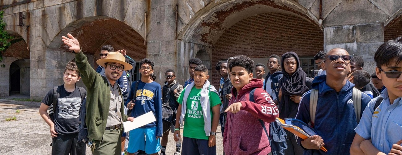 FOPO School Group Ranger with a school group pointing to something inside a fort