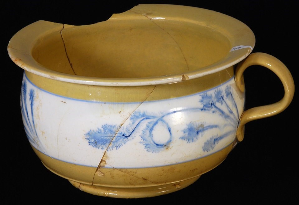 Round chamber pot with handle. Yellow with a blue and white design around middle.