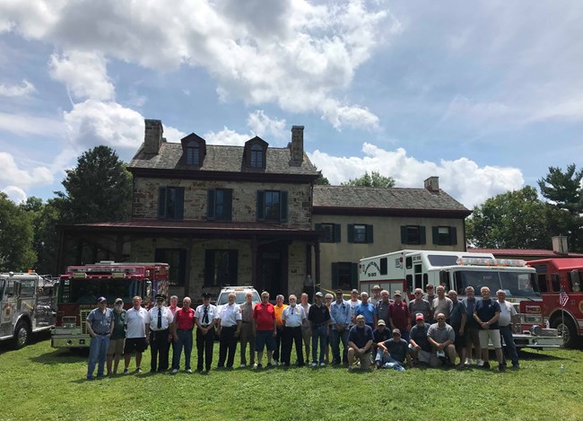 Firefighters from the 1979 fires pose in front of the building they saved.