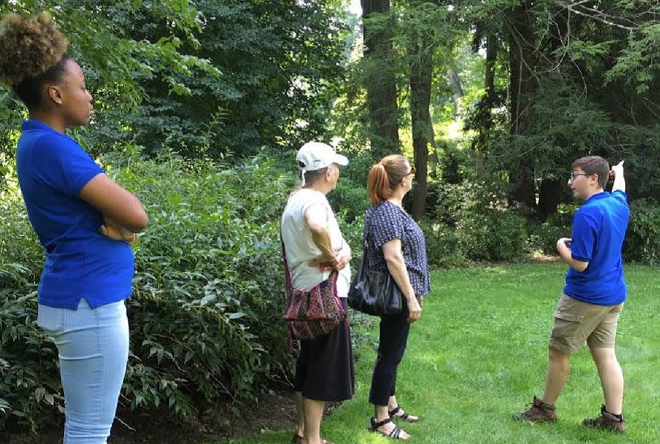 Two youth interns guiding visitors