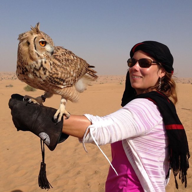Fig 3. kari p. woman wearing scarf on head holding owl on outstretched gloved arm