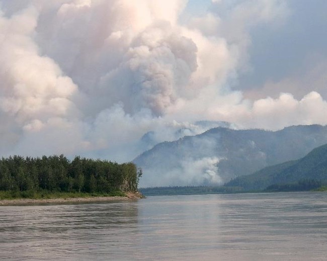 Figure 2. View from the Yukon River of the smoke column building on the Trout Creek Fire July 15, 2017.  (NPS Photo).