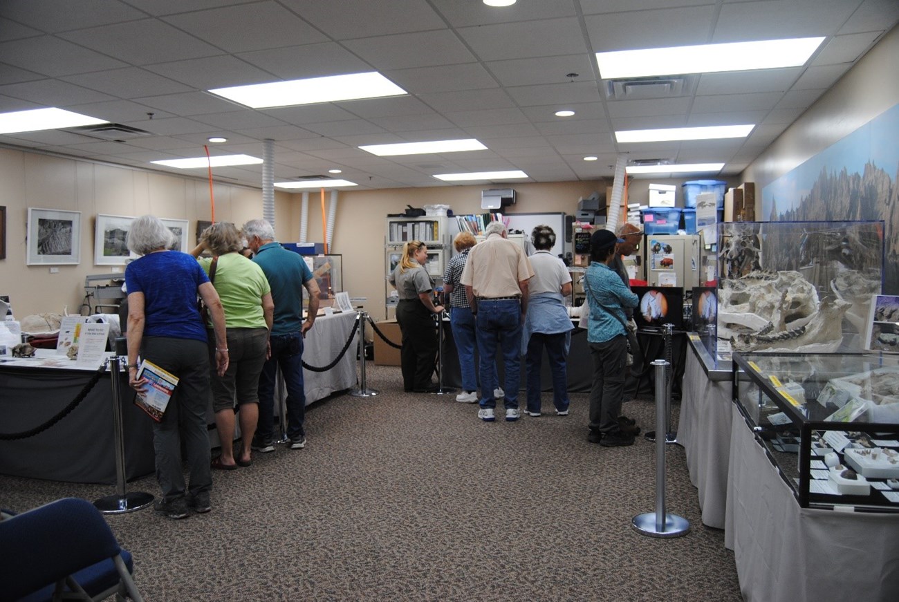 Visitors viewing fossil exhibits and talking to paleontologists and park rangers