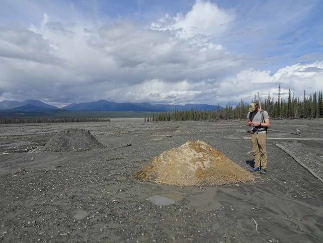 Figure7_web A researcher stands near a mound of rock transported by the debris flow.