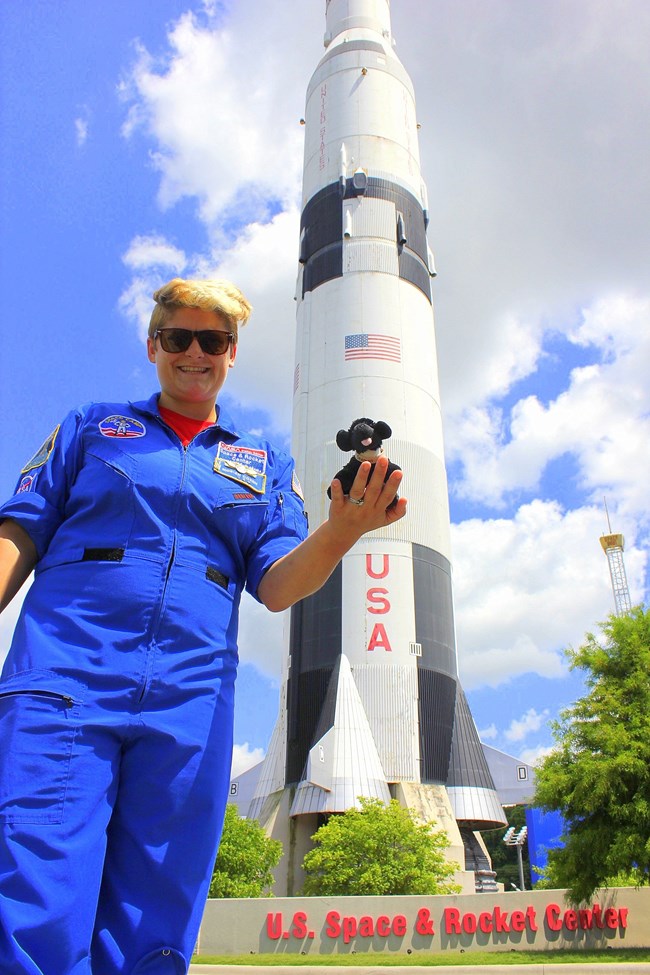 Final Moriah women holding toy dog in front of a rocket