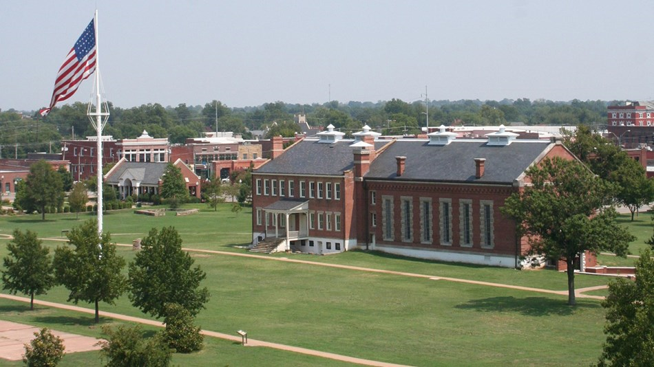 American flag on a flag pole and brick Fort Smith National Historic Landmark building.