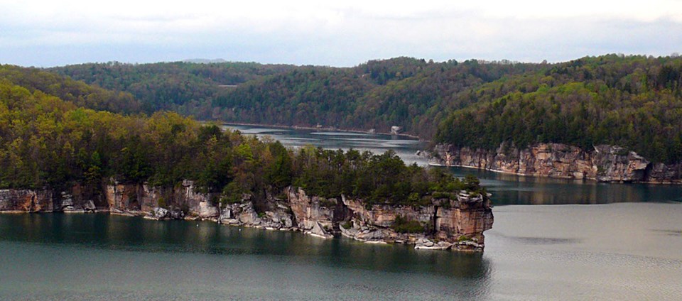 Aerial view of a lake with rock outcroppings and forest
