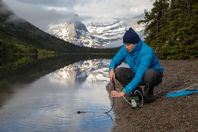Visitor filtering water at Cosley Lake Visitor Filtering Water from Cosley Lake in Glacier National Park