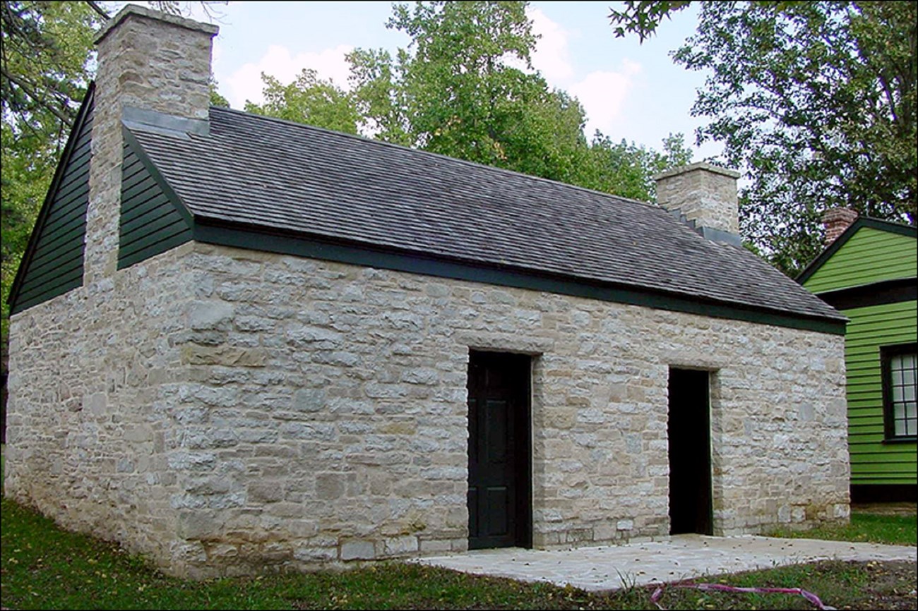 Photo of a stone house with two doors.