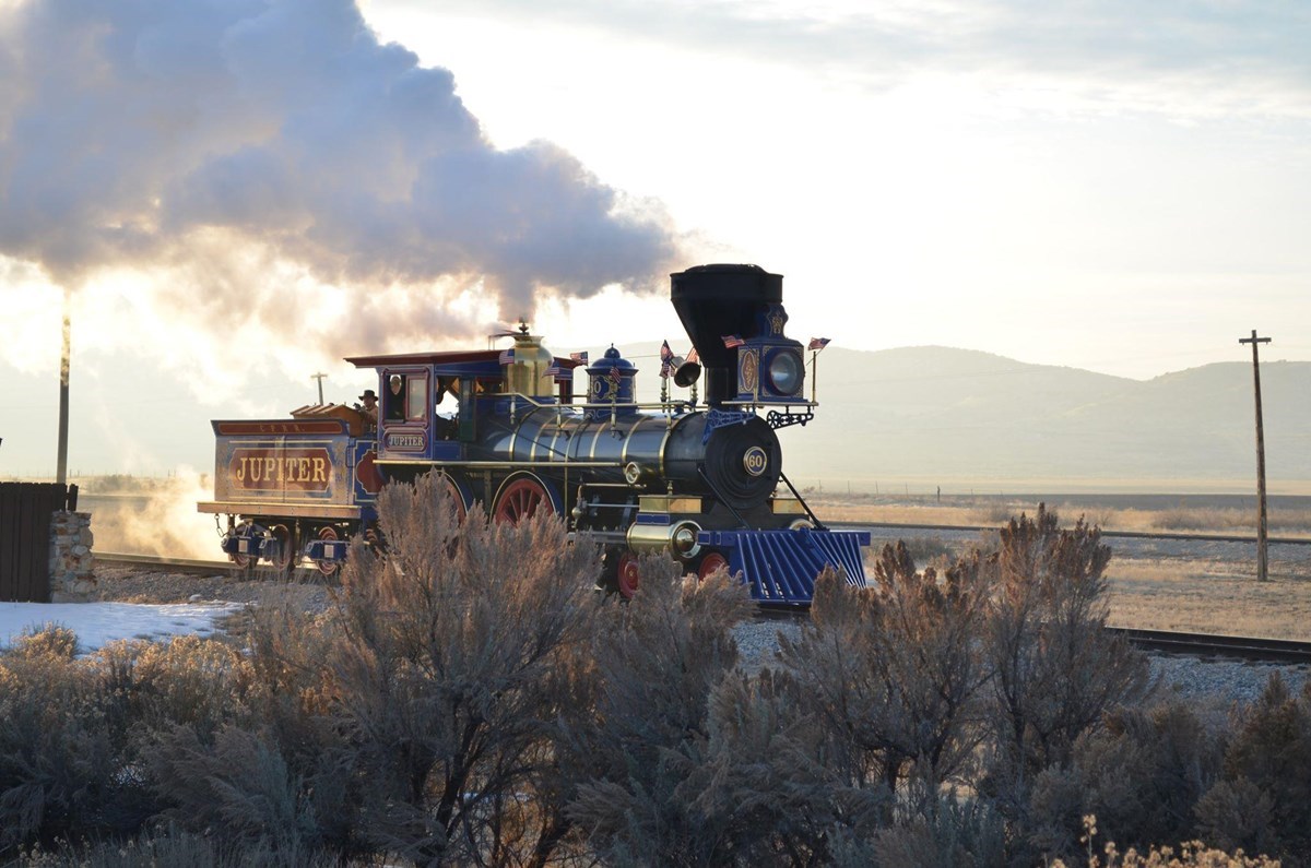 Steam locomotive running on a railroad track in winter