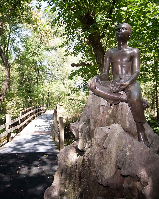 statue and forest trail