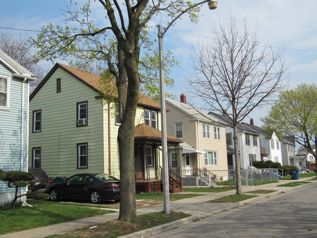 Six houses in a row with a street in front.