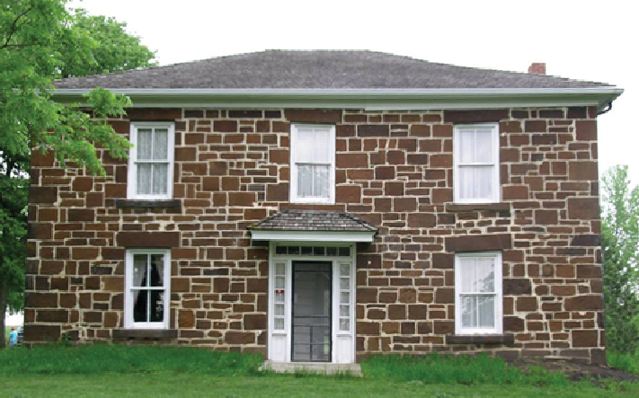 George B. Hitchcock House Restored Brick building on a green lawn.