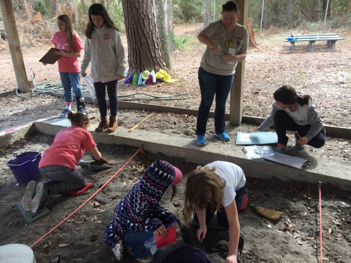 Archeologist assisting Girl scouts excavate in “Shiner’s Trench” at Fort Frederica National Monument