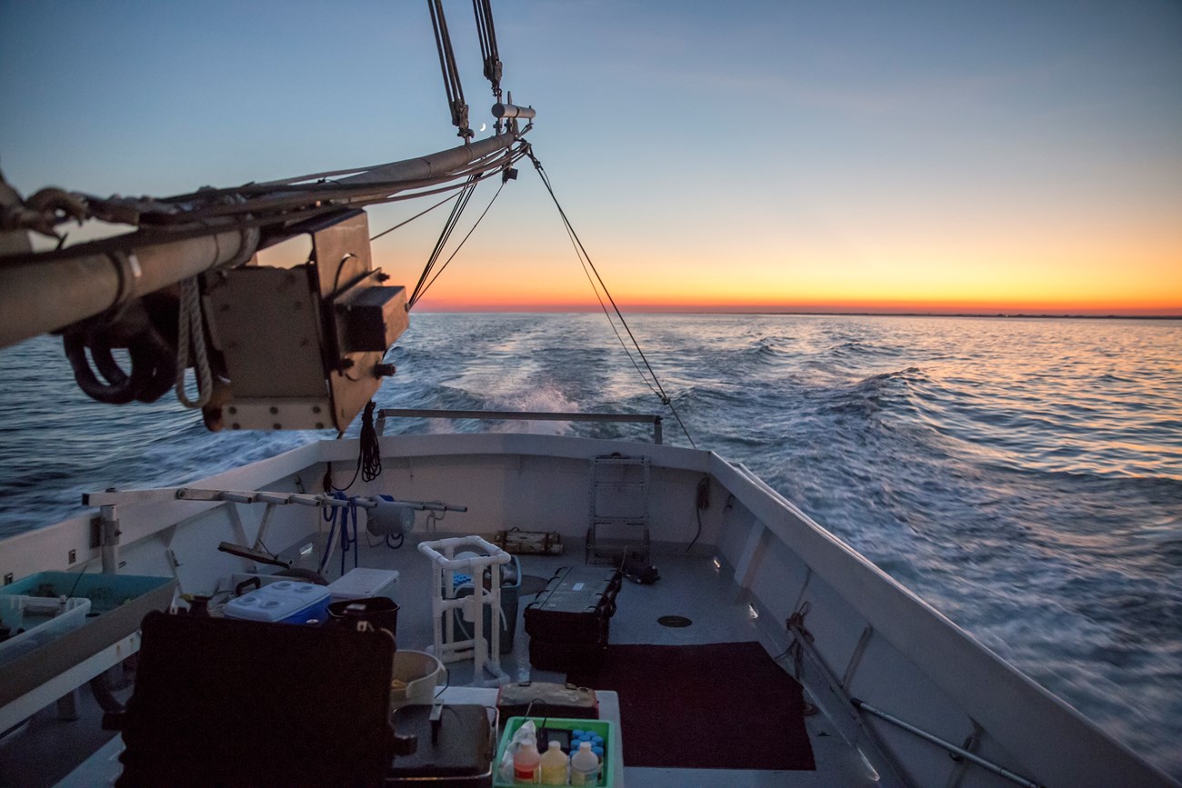 lt= The research vessel used by Stony Brook University cruises through Jamaica Bay at sunset