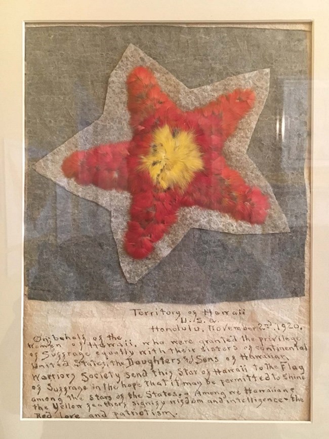 Hawaii-Ratification-Star, a star made of red feather with a yellow center. NPS photo. Hawaii-Ratification-Star