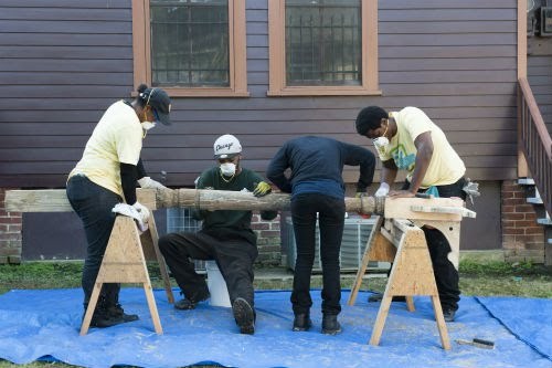 Men and women work on a post.