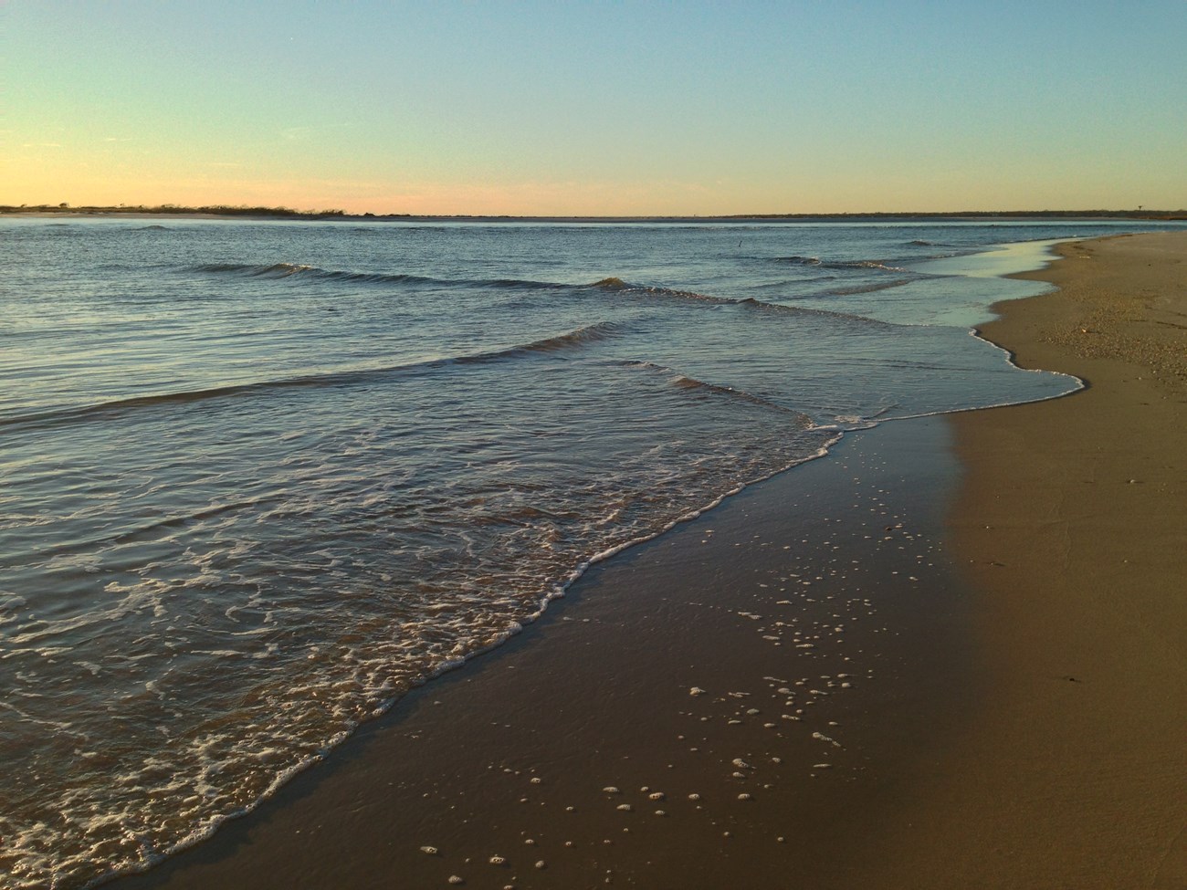 waves lap the shore during sunset