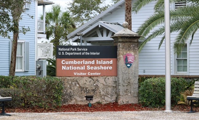Cumberland Island National Seashore Sign in front of a building that reads Cumberland Island National Seashore