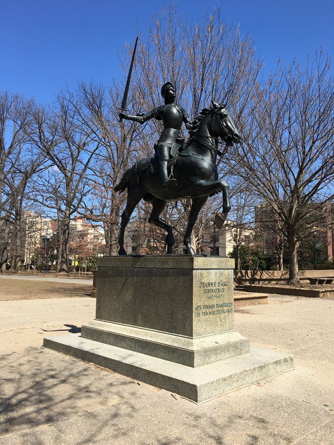 bronze statue of a young woman on horseback with her sword drawn