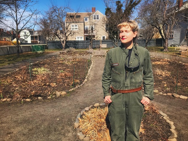 woman standing in a garden in a green jumpsuit