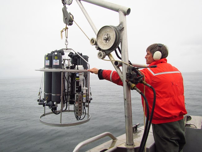 A CTD probe is being lowered into the water column to record vital characteristics of the seawater.