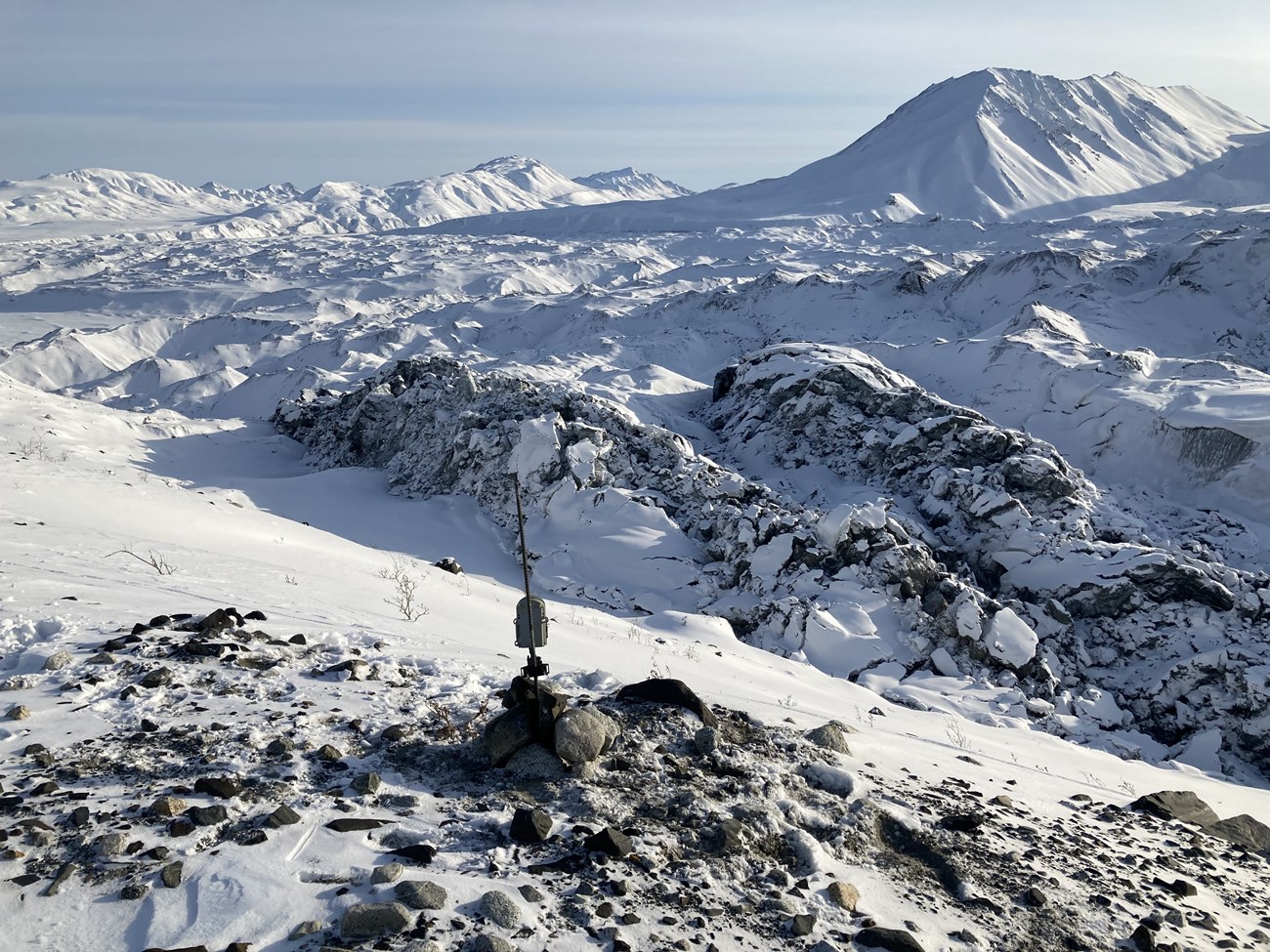 a camera perched on rocks overlooking a vast glacier