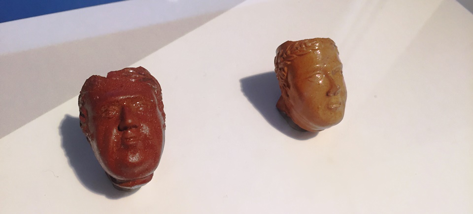 Two president pipe bowls mounted in an exhibit