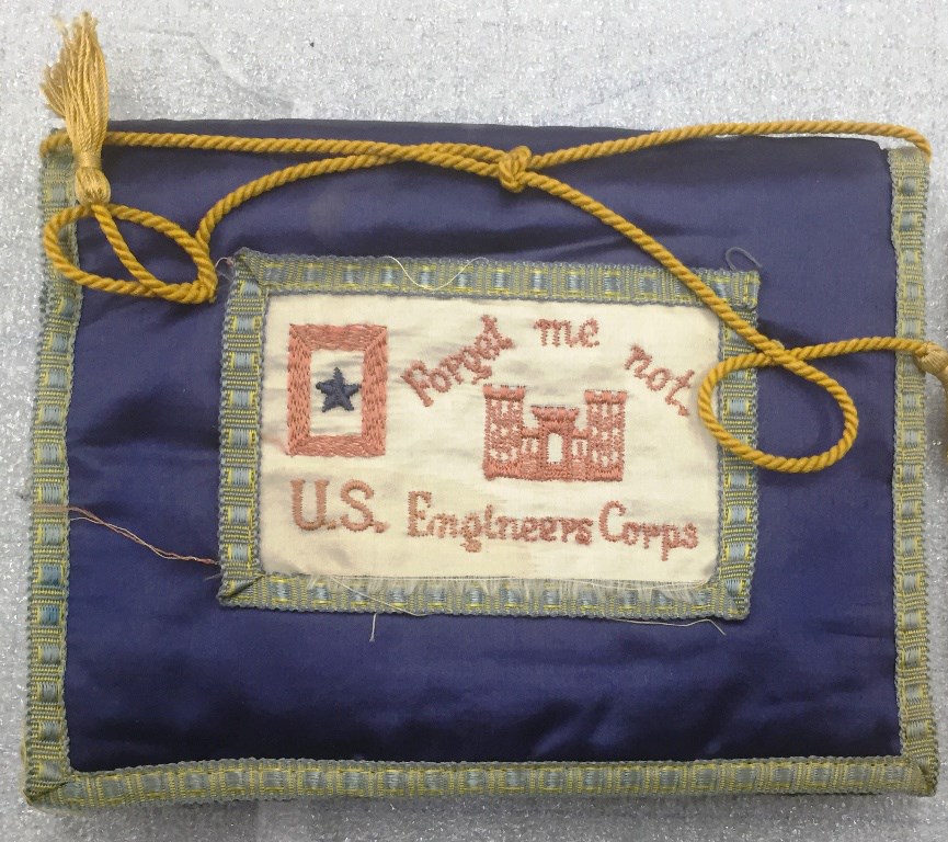 Silk envelope with blue border. Embroidered text reads "Forget me not, U.S. Engineers Corps." Also embroidered is an image of a castle and a blue star with red border.