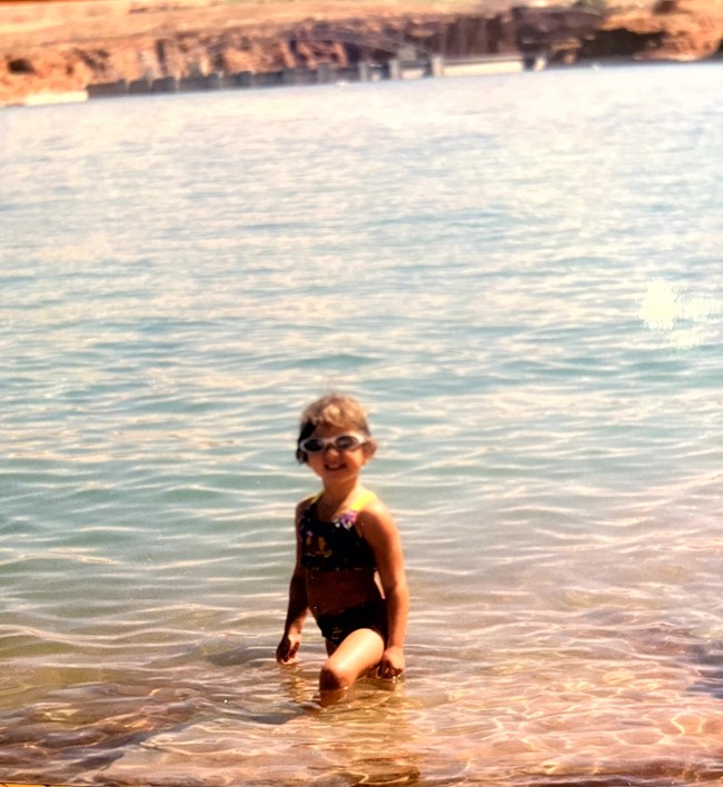 Kelsey Shores Park Story 1 Child swimms in lake, a cement dam is visiable in the background.