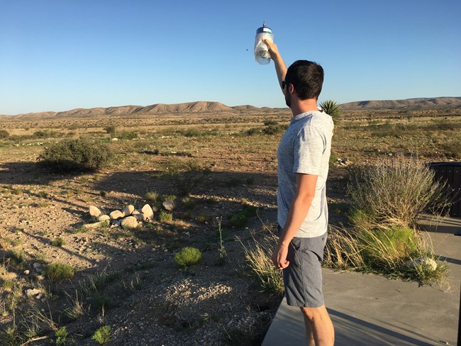 person holding up air canister to collect sample