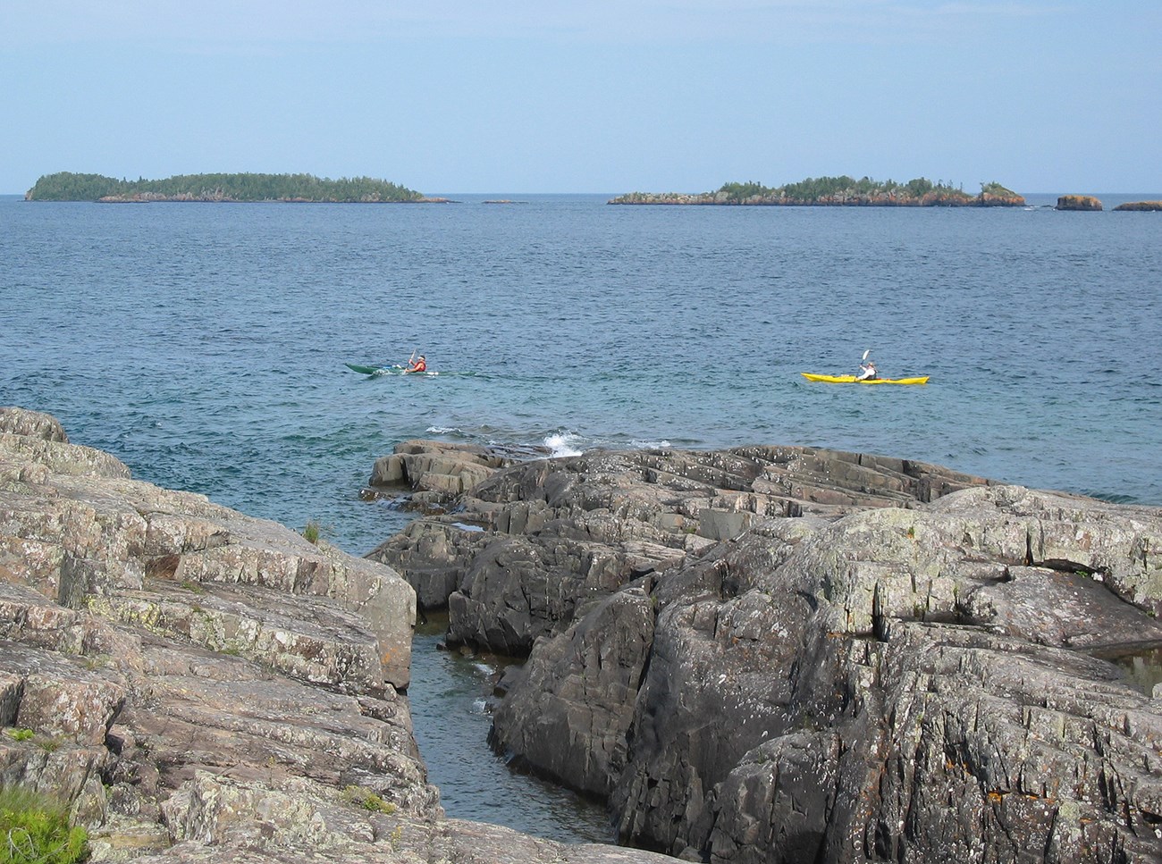 rocky shoreline and open water with 2 kayaks in view